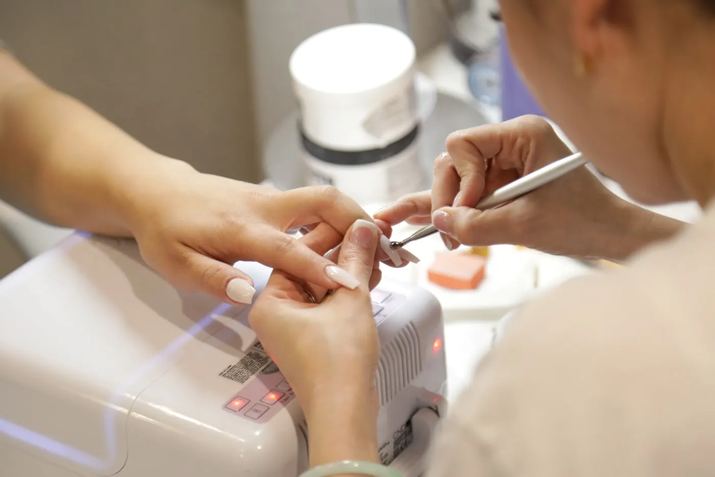 Nail technician working on a client manicure